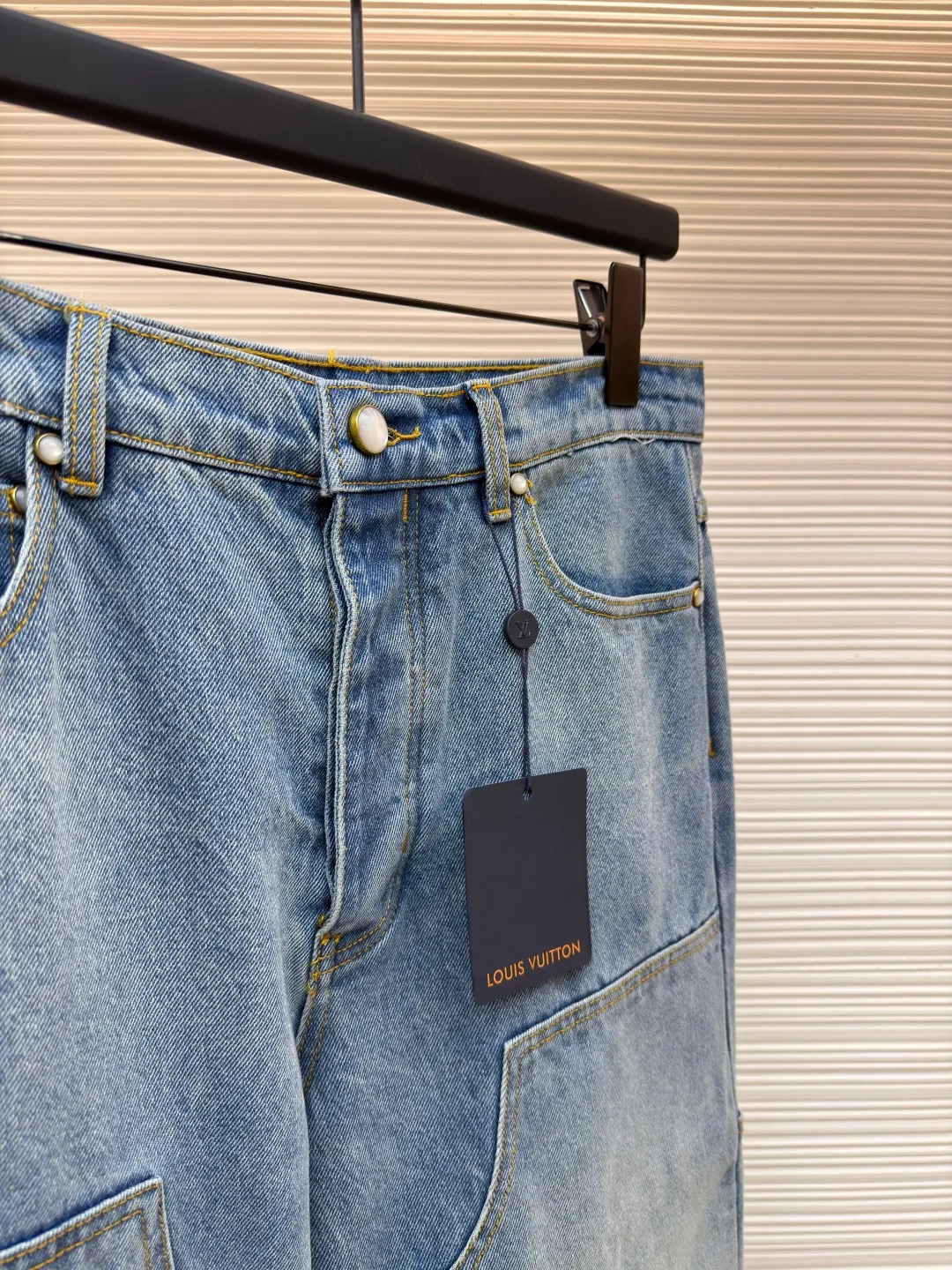 LOUIS VUITTON distressed washed blue denim trousers ●Original version: purchased and developed at 11999 ●Item number: 1682235-B15 ●Fabric: pure cotton denim ●Technology: laser cutting ●Color: blue ●Type: fitted version ●Weight: about 920 grams ●Size: 28-30-32-34-36 ●Description: Made of high-quality pure cotton denim, the fabric material ensures classic denim texture, durability and breathability. Classic washed colors are achieved through professional industrial washing processes. The function of washing is to soften the fabric and eliminate the stiffness of new cloth; by controlling the degree of fading, it can form a layered retro blue tone; and at the same time, it can prevent the garment from shrinking significantly in the future. The calm topstitching contrasts with the fabric but is not too knotty in stitching color to highlight the stitching structure and enhance the workwear style. The back pocket is top-stitched with the word LV: the logo on the chest pocket is embroidered by stitches, and the embroidery stitches are closely connected and evenly arranged in straight lines. Its function is to outline the outline of the logo in a delicate and extremely strong way. The edges are neat, wear-resistant and durable, and are in line with the functional attributes of workwear. Nubuck leather logo patch: High-quality nubuck leather is laser-cut and embossed with the brand logo and sewn on the back of the pants. What it does is introduce a luxuriously soft touch that creates a premium contrast with stiff denim. The ticket bag is equipped with a logo patch, which fixes the brand leather logo on this small pocket and becomes a refined identity embellishment. Pearlescent effect buttons and rivets: Replace the metal hardware of traditional workwear with fasteners with a warm pearlescent effect. Its function is to enhance the sophistication and uniqueness of the piece in the details, while retaining the functional rivet reinforcement. The overall wiring is straight and delicate, the fabric is comfortable and soft, and the color is consistent without color difference. It can be matched with the same style to create a fashionable look and control various occasions. Customized accessories, complete with three standards, same style for men and women!